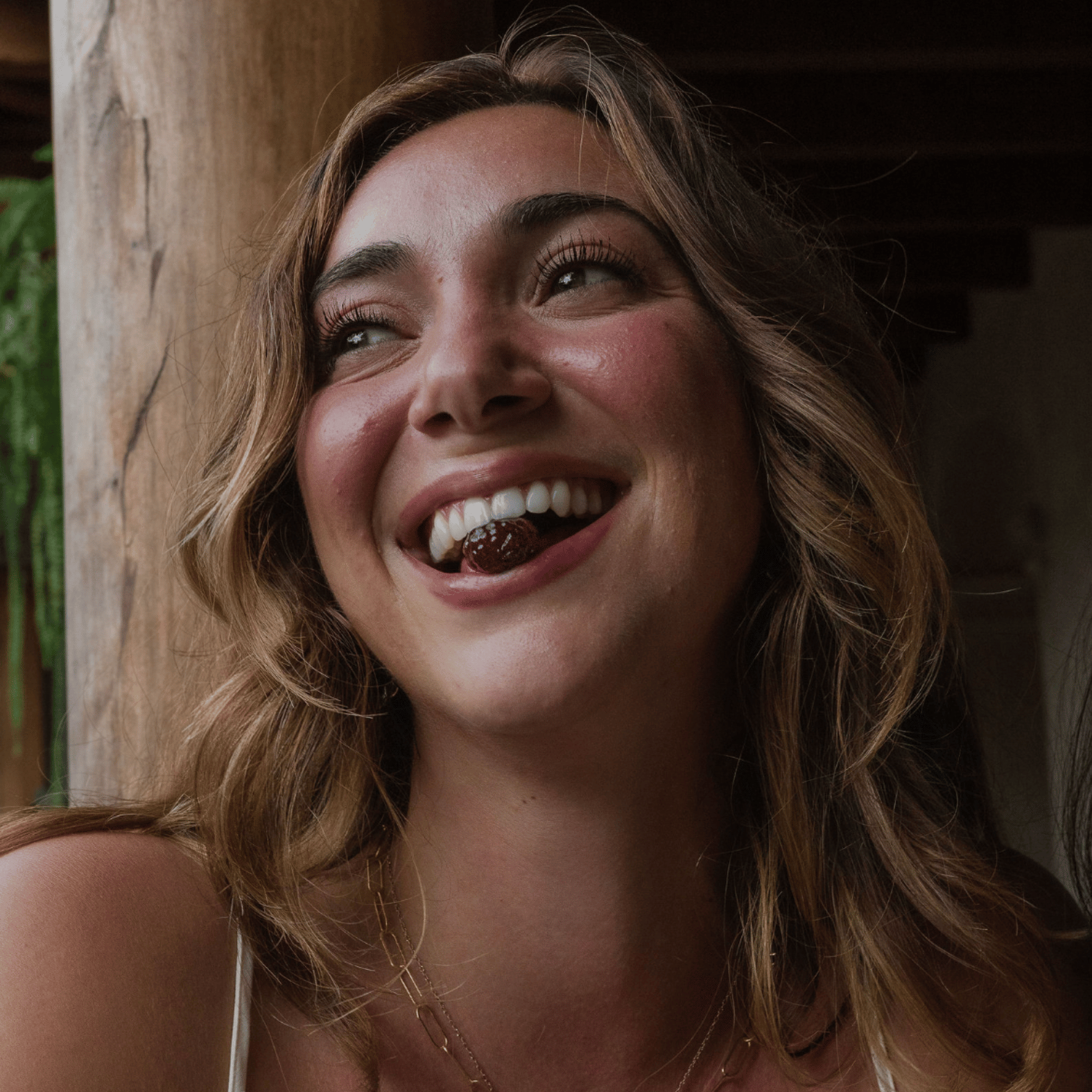 woman smiling showing a gummy between her teeth.