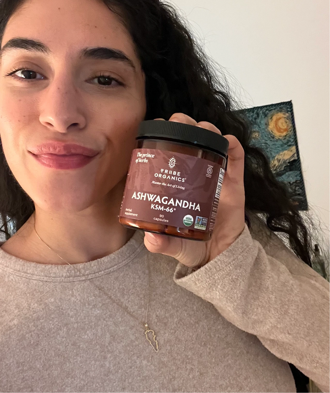 Person holding the Tribe Organic's Ashwagandha Capsules bottle.