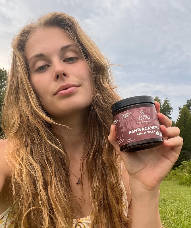 Person holding the Tribe Organic's Ashwagandha Capsules bottle.