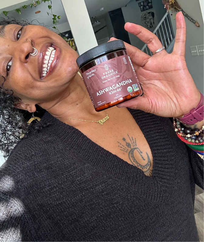 Person holding the Tribe Organic's Ashwagandha Capsules bottle.