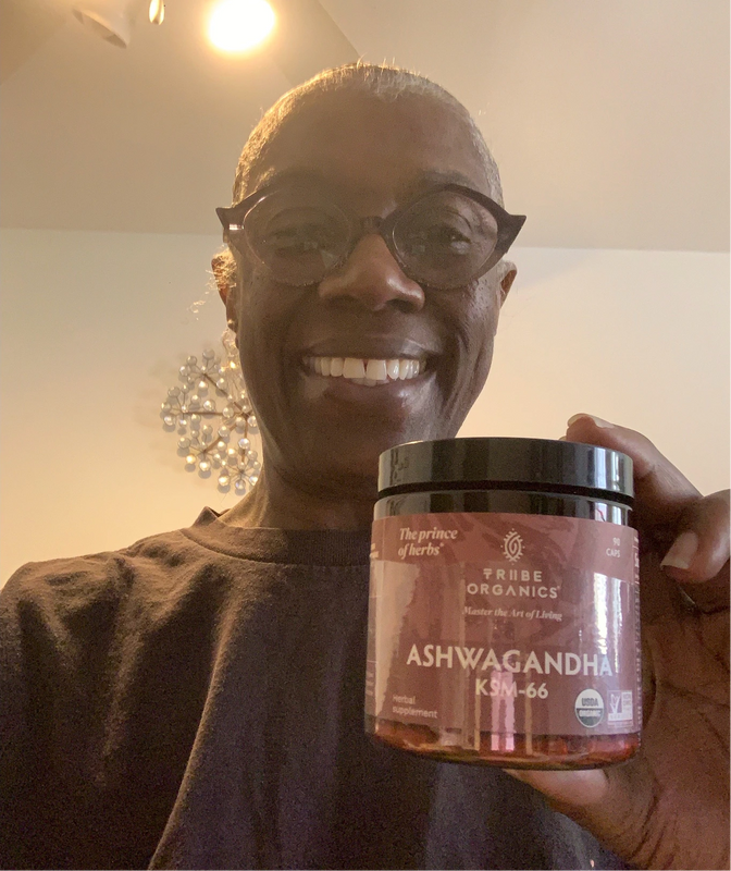 Person holding the Tribe Organic's Ashwagandha Capsules bottle.