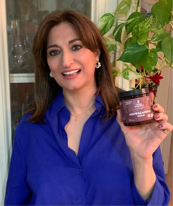 Person holding the Tribe Organic's Ashwagandha Capsules bottle.