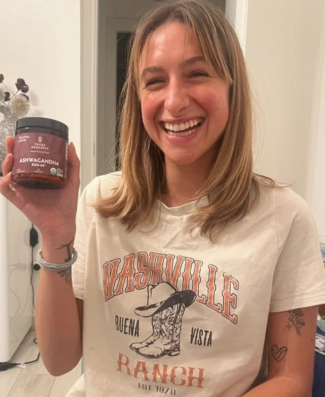 Person holding the Tribe Organic's Ashwagandha Capsules bottle.