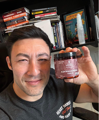 Person holding the Tribe Organic's Ashwagandha Capsules bottle.