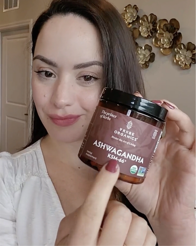 Person holding the Tribe Organic's Ashwagandha Capsules bottle.