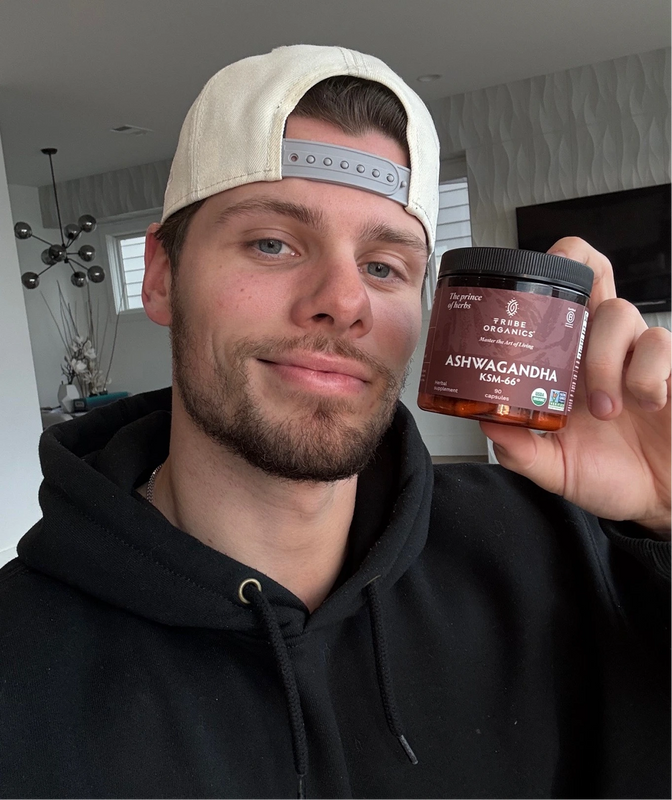 Person holding the Tribe Organic's Ashwagandha Capsules bottle.
